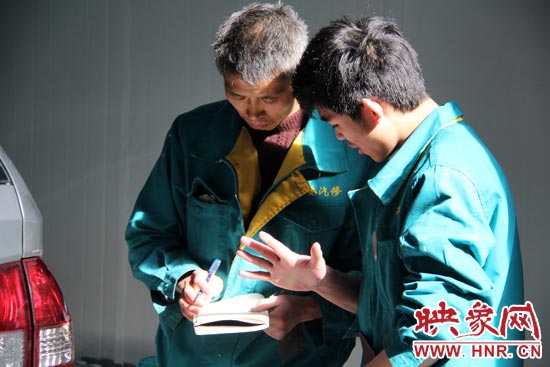 在汽修廠干了20來(lái)年的李師傅（左）在教一個(gè)聾啞人修車(chē)技巧