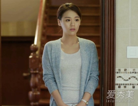 灰色開衫內(nèi)搭圓領(lǐng)的米色T恤，優(yōu)雅知性