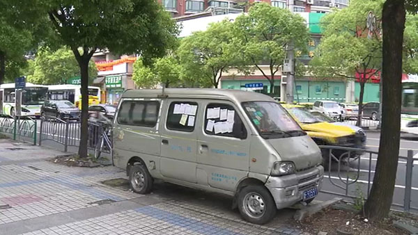 被棄置在人行道上的面包車。