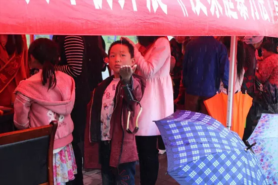 因為雨下的太大，小男孩玩起了接水游戲。