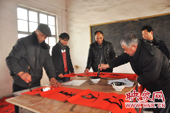 鞏義市魯莊鎮(zhèn)農(nóng)民書法愛好者正在寫春聯(lián)。