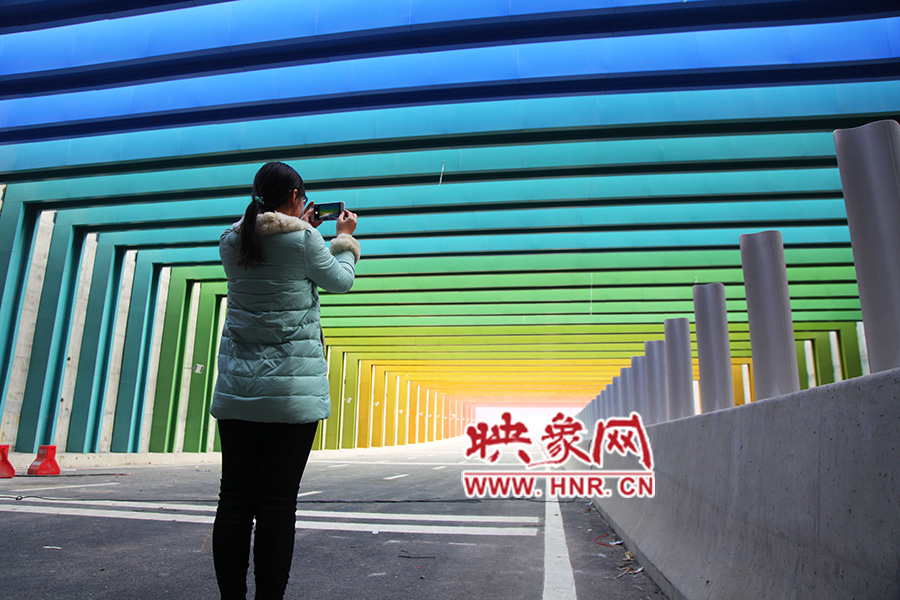 一女孩拿出手機(jī)拍照。